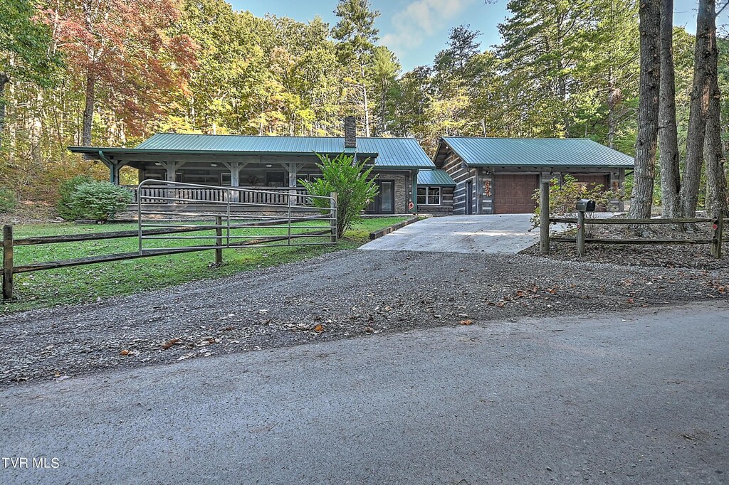 4610 Greene Mountain Rd, Greeneville, TN 37743 - view of front of house with a garage, stone siding, and metal roof