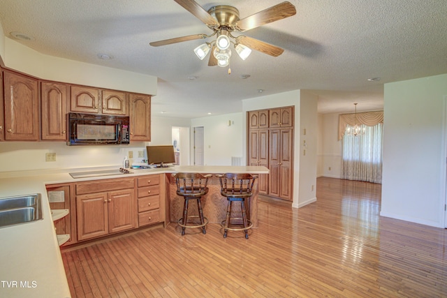 142 Laurel Acres Ct, Jonesborough, TN 37659 - kitchen with black appliances, a peninsula, light countertops, light wood-style floors, and a ceiling fan