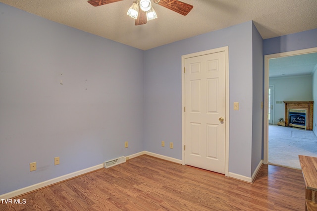 142 Laurel Acres Ct, Jonesborough, TN 37659 - empty room with ceiling fan, wood finished floors, a fireplace, and a textured ceiling