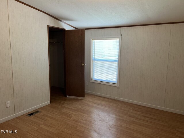 157 Power House Holw, Clintwood, VA 24228 - unfurnished bedroom with visible vents, wood finished floors, a closet, crown molding, and vaulted ceiling