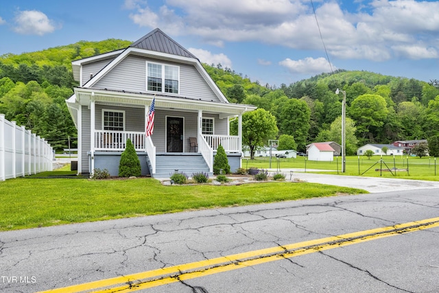 bungalow with fence, a porch, and a front lawn