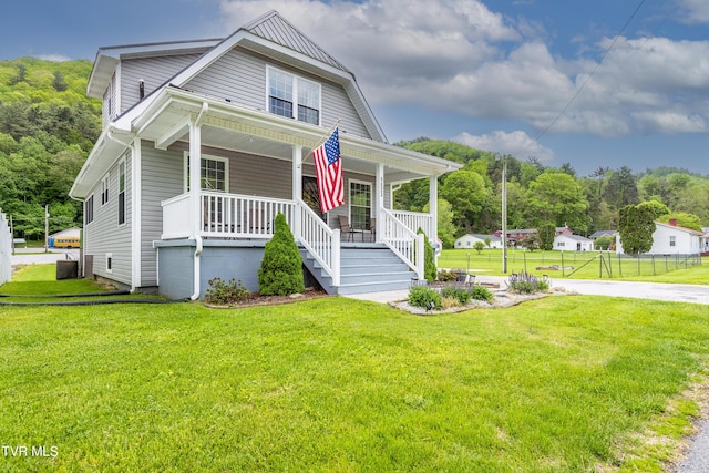 bungalow featuring fence, covered porch, a front yard, and cooling unit