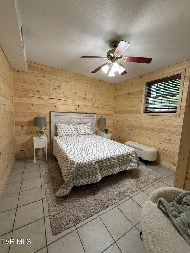 1209 Beechwood Dr, Johnson City, TN 37604 - bedroom with wooden walls, light tile patterned floors, a textured ceiling, and ceiling fan