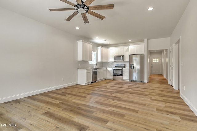 703 Swadley Rd, Johnson City, TN 37601 - kitchen featuring appliances with stainless steel finishes, a ceiling fan, a sink, light wood-style flooring, and white cabinets