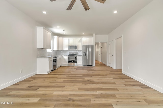 703 Swadley Rd, Johnson City, TN 37601 - kitchen featuring appliances with stainless steel finishes, a ceiling fan, a sink, tasteful backsplash, and white cabinetry
