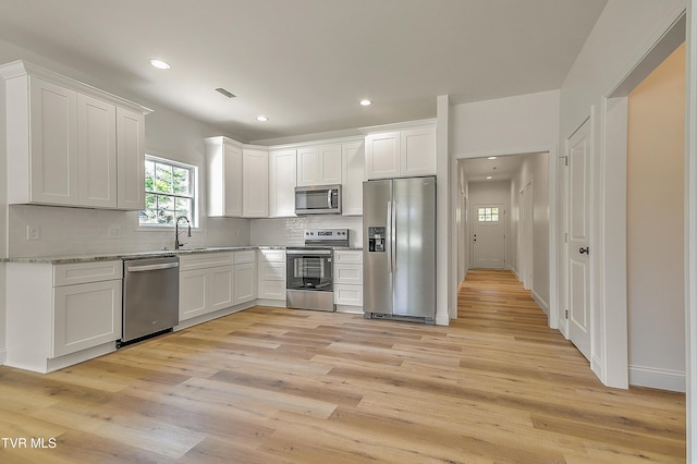 703 Swadley Rd, Johnson City, TN 37601 - kitchen with stainless steel appliances, decorative backsplash, light wood-style flooring, recessed lighting, and white cabinetry
