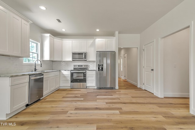 703 Swadley Rd, Johnson City, TN 37601 - kitchen featuring stainless steel appliances, a sink, decorative backsplash, light wood finished floors, and white cabinets