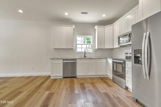 703 Swadley Rd, Johnson City, TN 37601 - kitchen featuring appliances with stainless steel finishes, a sink, white cabinetry, light wood-type flooring, and recessed lighting