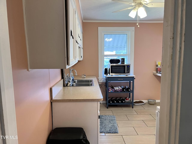 home office with ornamental molding, a sink, and a ceiling fan