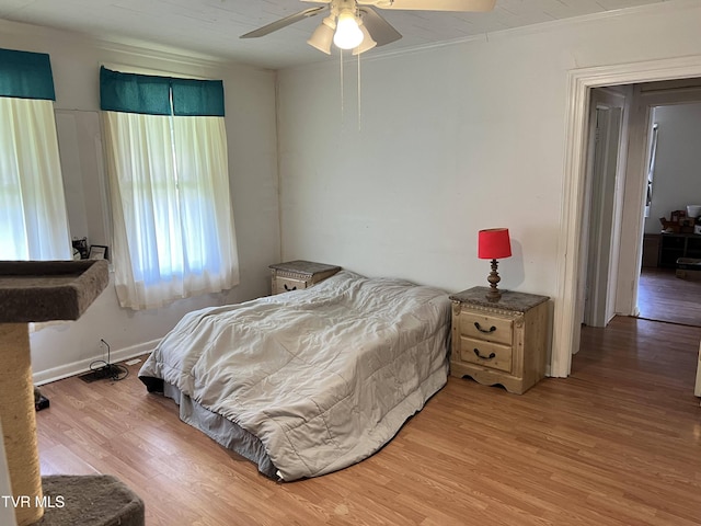 bedroom with baseboards, ceiling fan, light wood-style floors, and ornamental molding