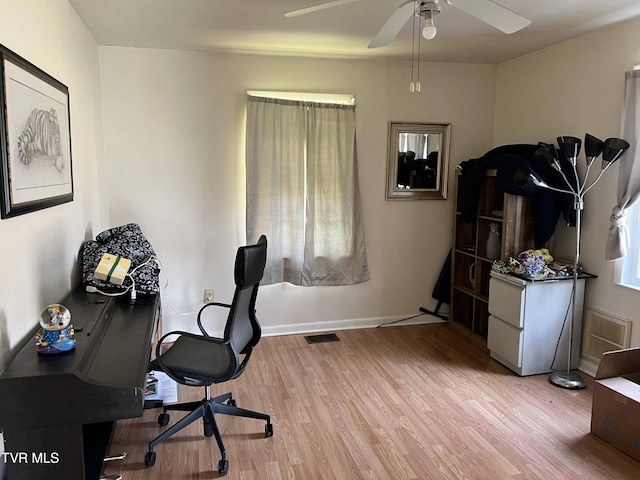 office area with a ceiling fan, light wood-style flooring, baseboards, and visible vents