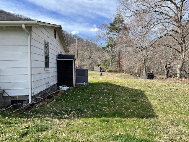 view of yard featuring fence and central AC unit