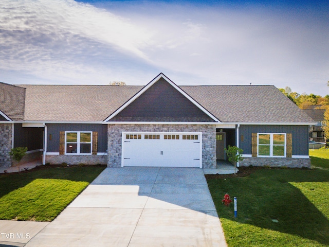 view of front of property with a garage, a front yard, driveway, stone siding, and roof with shingles