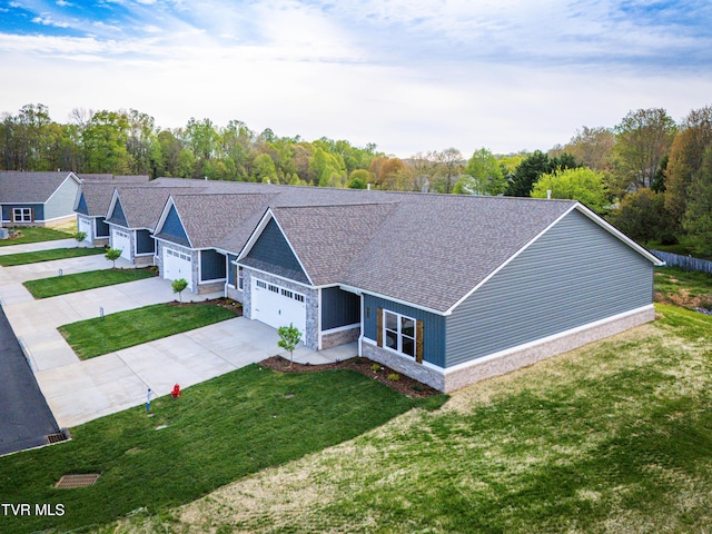 view of front of house with a garage, driveway, stone siding, and a front lawn