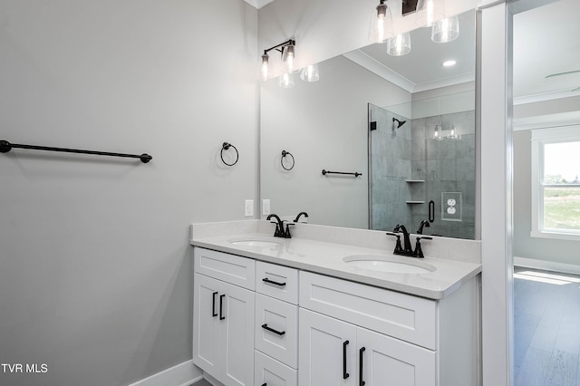 full bath featuring a shower stall, ornamental molding, double vanity, wood finished floors, and baseboards