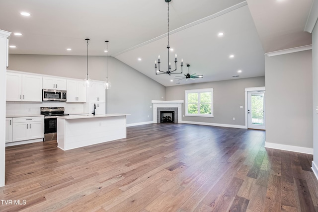 unfurnished living room featuring a chandelier, light wood finished floors, a sink, high vaulted ceiling, and a tile fireplace
