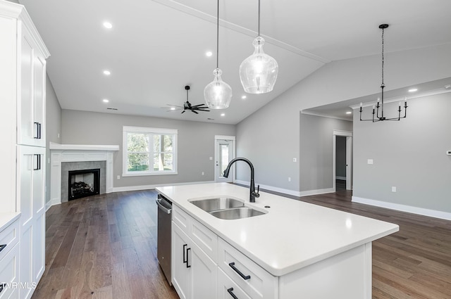 kitchen with open floor plan, a sink, stainless steel dishwasher, dark wood-type flooring, and lofted ceiling