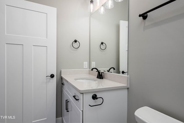 half bathroom with vanity and toilet