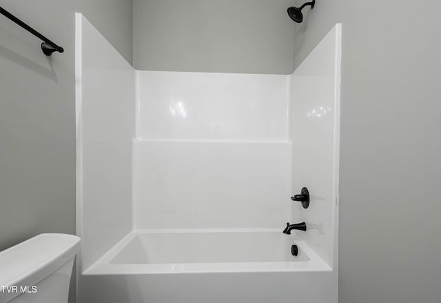 bathroom with toilet and bathing tub / shower combination