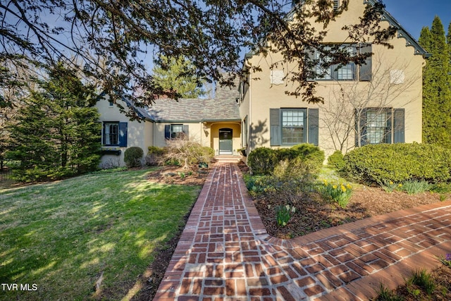 view of front of house with stucco siding and a front lawn