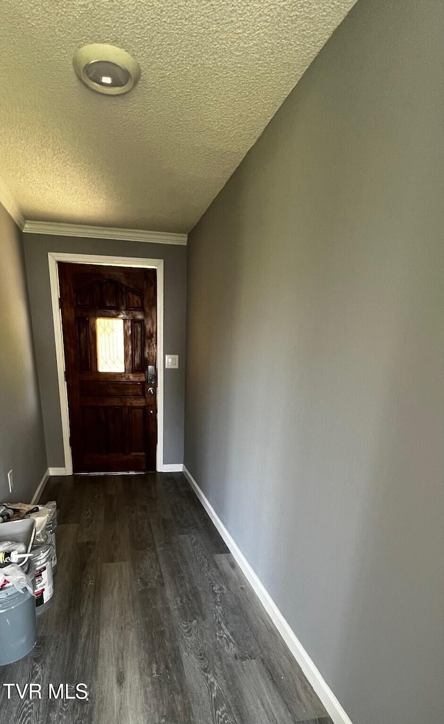 entryway with dark wood-style flooring, baseboards, crown molding, and a textured ceiling