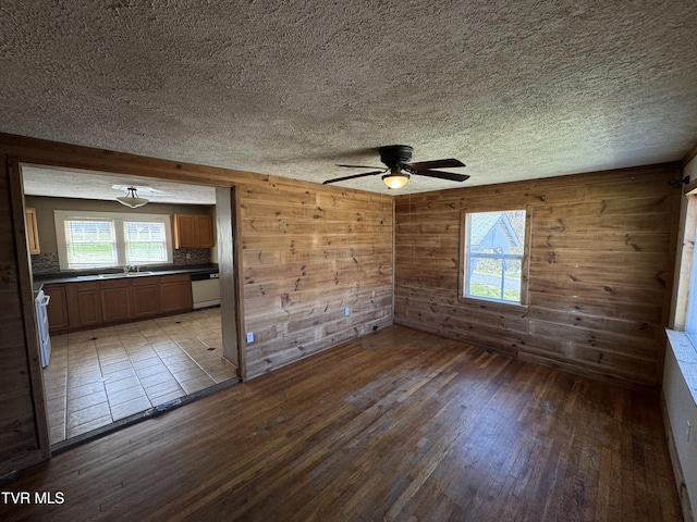 interior space with ceiling fan, light wood-style flooring, and wooden walls