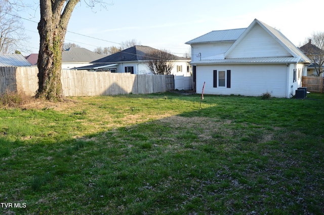 view of yard with central air condition unit and fence