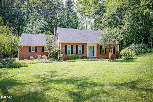 view of front of property featuring brick siding, a chimney, a shingled roof, and a front yard