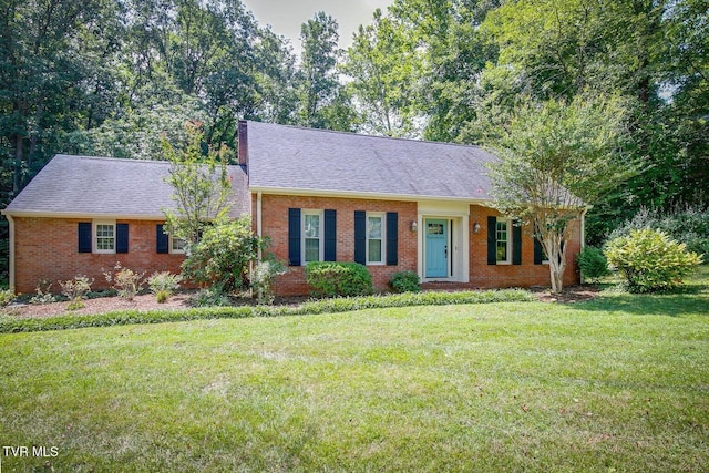 view of front of property featuring brick siding, a shingled roof, and a front lawn