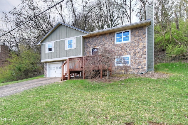 view of front of house featuring stone siding, aphalt driveway, a front yard, a garage, and a chimney