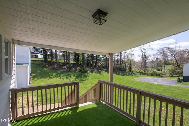 wooden terrace featuring a yard