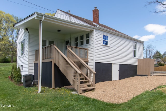 back of house with central AC, a deck, a chimney, stairs, and a yard