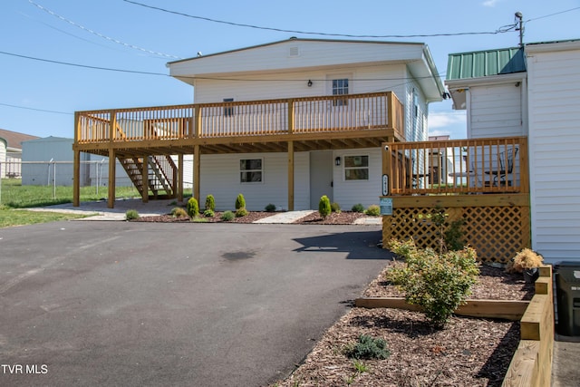 rear view of house with stairs and a deck
