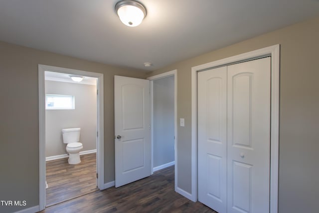 unfurnished bedroom featuring a closet, dark wood-style flooring, and baseboards