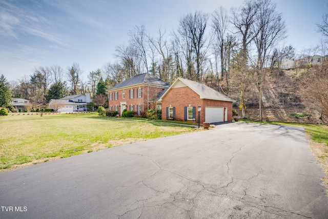 1221 Radcliffe Ave, Kingsport, TN 37664 - colonial inspired home with brick siding, aphalt driveway, an attached garage, and a front lawn