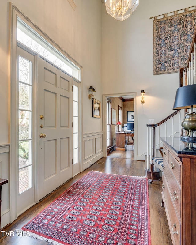 1221 Radcliffe Ave, Kingsport, TN 37664 - foyer entrance featuring a decorative wall, a chandelier, wood finished floors, stairway, and wainscoting