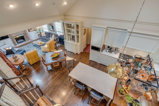 1221 Radcliffe Ave, Kingsport, TN 37664 - living room featuring dark wood finished floors, vaulted ceiling, recessed lighting, and a fireplace