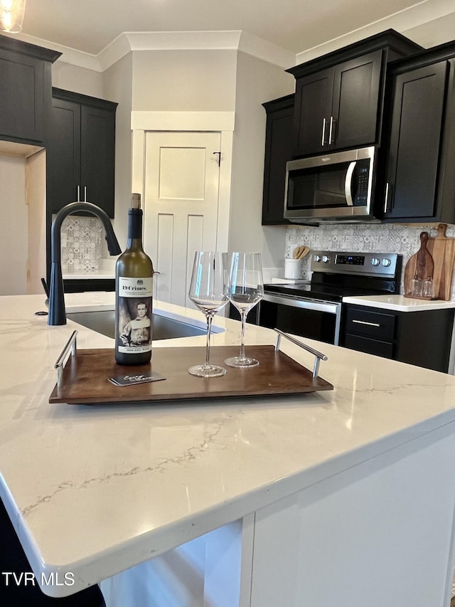 1270 Cabot Cv, Jonesborough, TN 37659 - kitchen featuring appliances with stainless steel finishes, dark cabinets, decorative backsplash, ornamental molding, and light stone counters