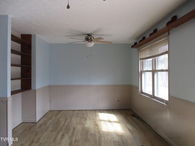 145 Rock City Rd, Kingsport, TN 37664 - spare room featuring a ceiling fan, wood finished floors, a textured ceiling, and wainscoting