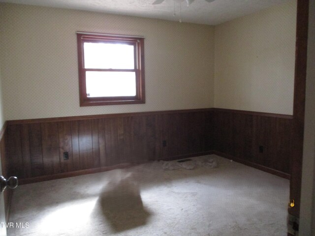 145 Rock City Rd, Kingsport, TN 37664 - spare room with wallpapered walls, carpet floors, wooden walls, ceiling fan, and wainscoting