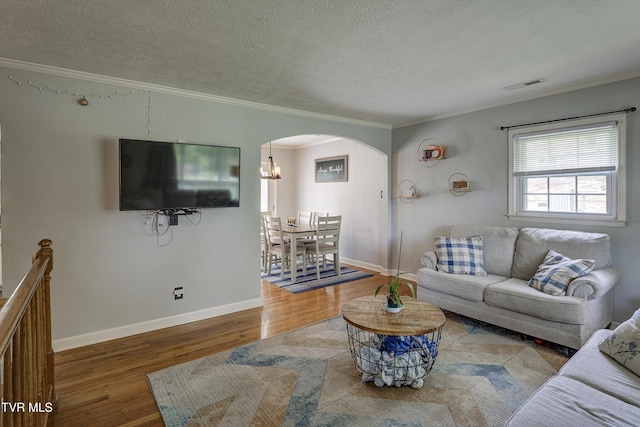 232 Meadow Dr, Bristol, TN 37620 - living area featuring arched walkways, wood finished floors, a textured ceiling, ornamental molding, and a chandelier