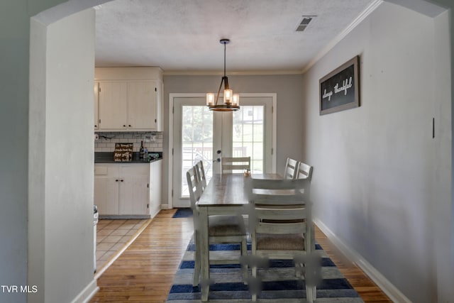 232 Meadow Dr, Bristol, TN 37620 - dining space with light wood-style floors, arched walkways, crown molding, a chandelier, and french doors
