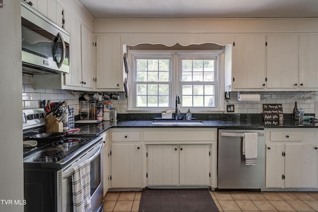 232 Meadow Dr, Bristol, TN 37620 - kitchen featuring appliances with stainless steel finishes, tasteful backsplash, light tile patterned floors, ornamental molding, and white cabinets