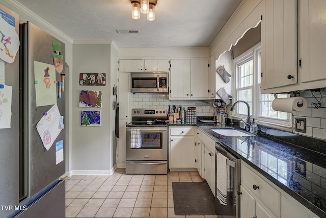 232 Meadow Dr, Bristol, TN 37620 - kitchen featuring stainless steel appliances, tasteful backsplash, crown molding, light tile patterned flooring, and white cabinetry