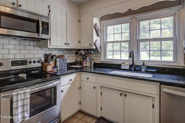 232 Meadow Dr, Bristol, TN 37620 - kitchen with appliances with stainless steel finishes, backsplash, white cabinets, and ornamental molding