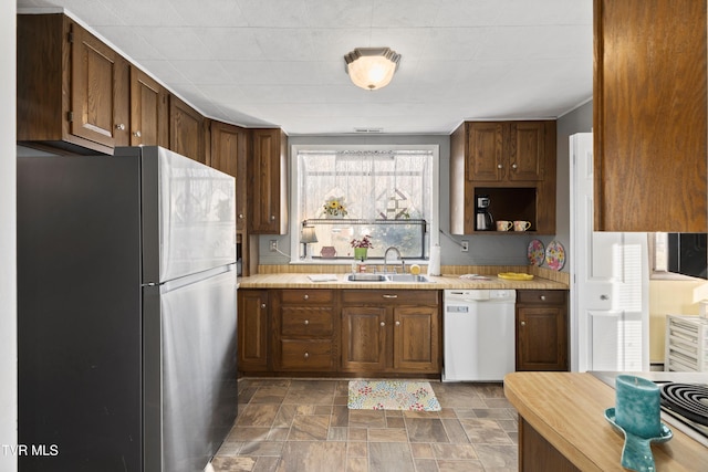 4245 Maplewood St, Kingsport, TN 37660 - kitchen with light countertops, stone finish flooring, a sink, freestanding refrigerator, and dishwasher