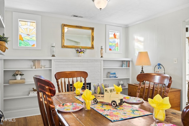 4245 Maplewood St, Kingsport, TN 37660 - dining space featuring wood finished floors, crown molding, a fireplace, and visible vents
