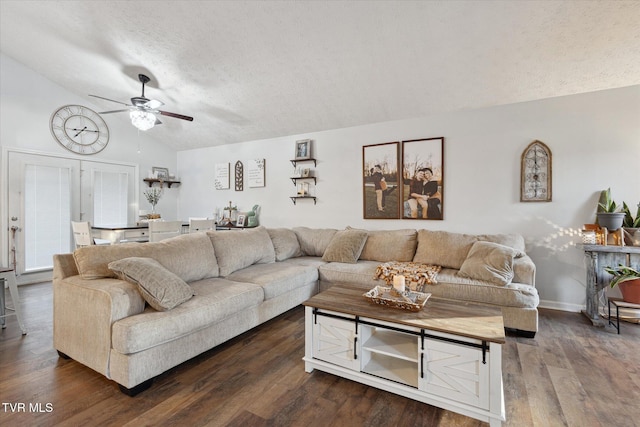 living area with a textured ceiling, baseboards, a ceiling fan, dark wood-type flooring, and lofted ceiling