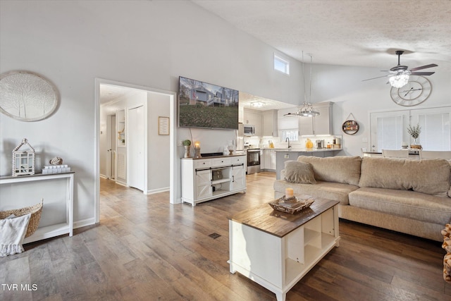 living room featuring high vaulted ceiling, a textured ceiling, baseboards, ceiling fan, and hardwood / wood-style floors