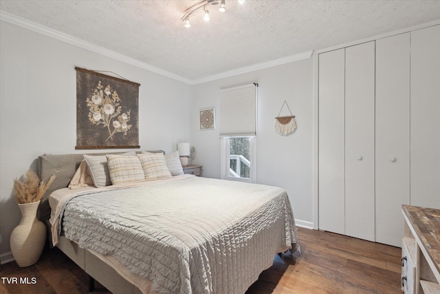 bedroom featuring a closet, wood finished floors, ornamental molding, and a textured ceiling